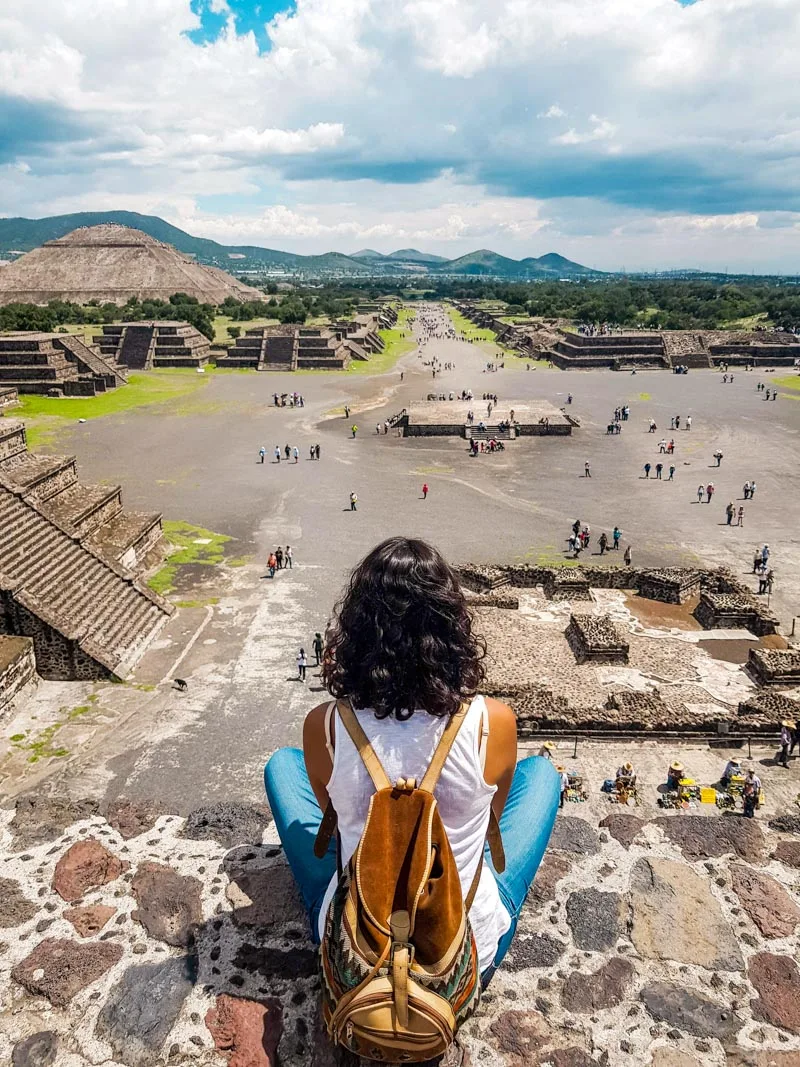 Woman sitting on top of the pyramid of the moon in teotihuacan