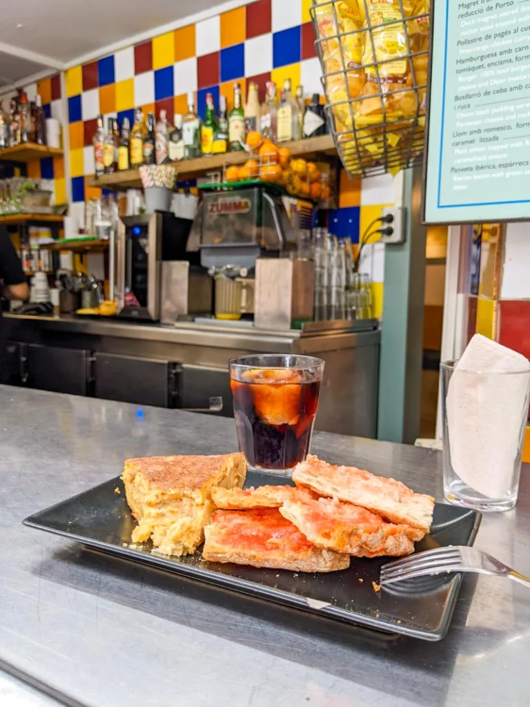 a slice of spanish tortilla with pan con tomate and a vermut at bar mendizabal, one of the best places to eat cheap in barcelona