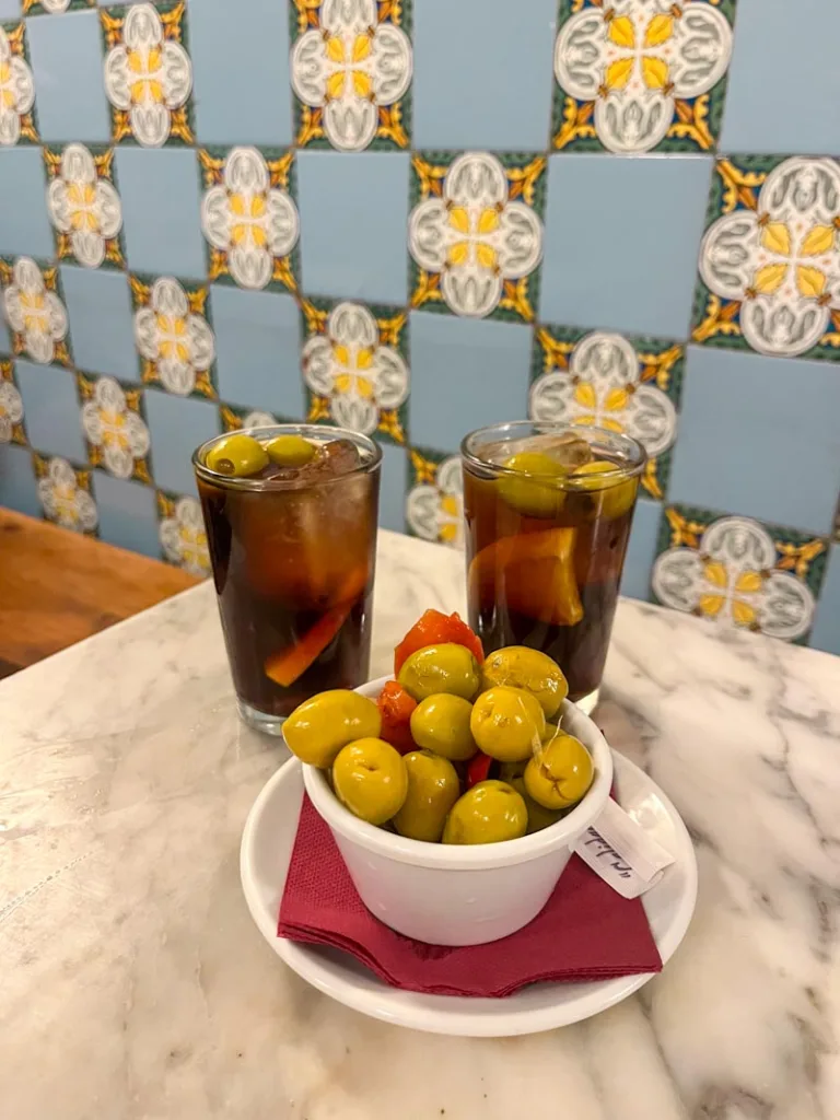 two vermut glass, and a small plate of olives at a traditional bar in barcelona