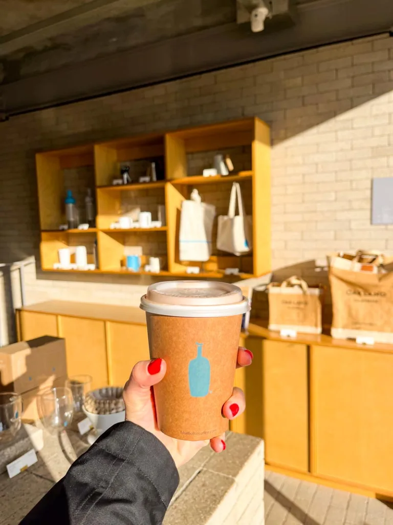 hand holding a coffee to go from blue bottle, one of the best cafes in bukchon hanok village in seoul