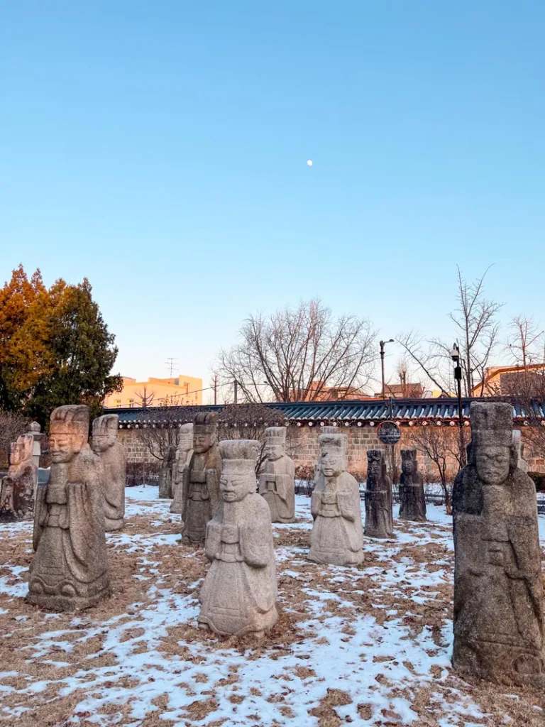 statues in the front patio of the national folk. museum in seoul