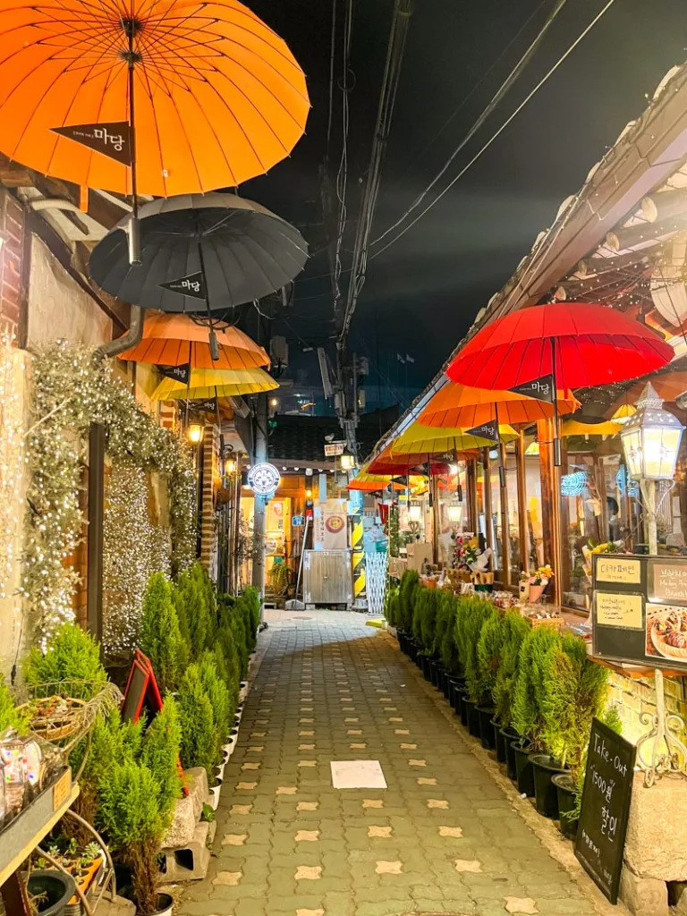 charming alleys of ikseon-dong at night, lined with fairy lights and colorful umbrellas