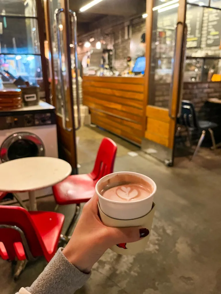 hand holding a cup of hot chocoalte at lay bricks, a coffee shop in Sinsadong
