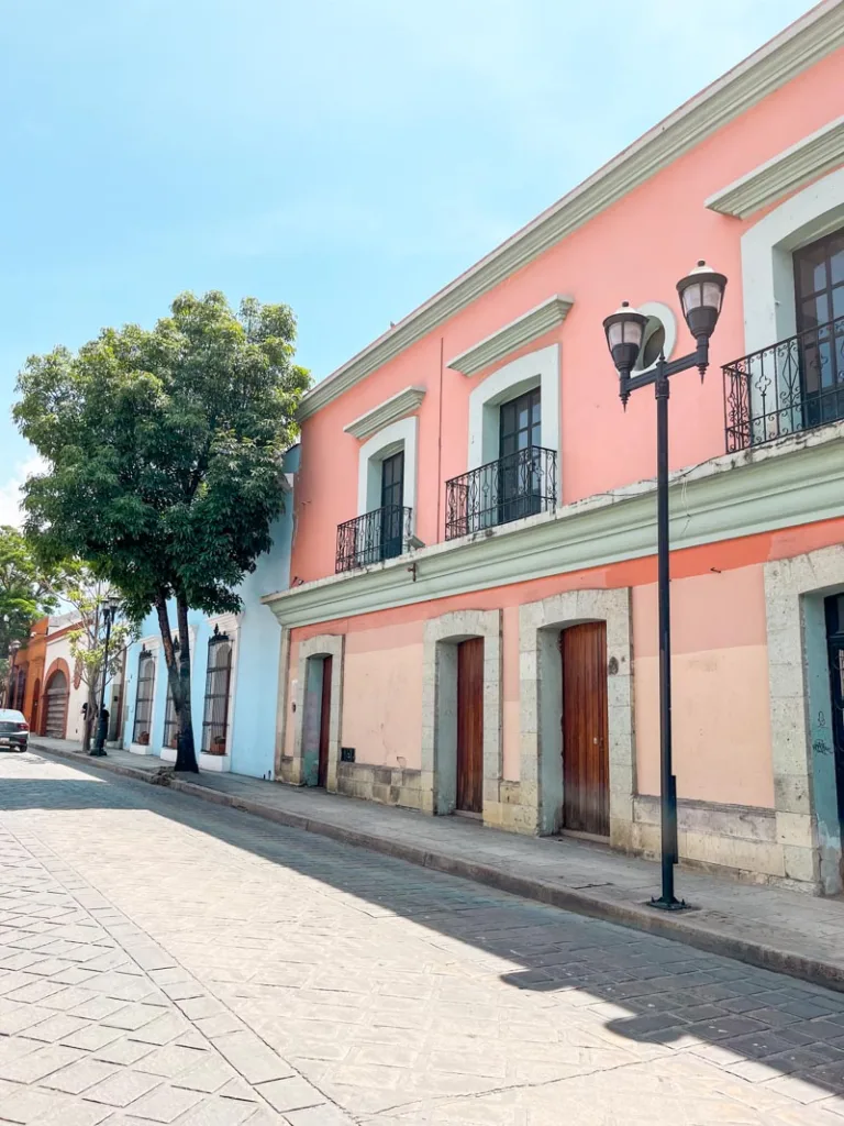 bubble gum pink house next to a powder blue one in oaxaca city