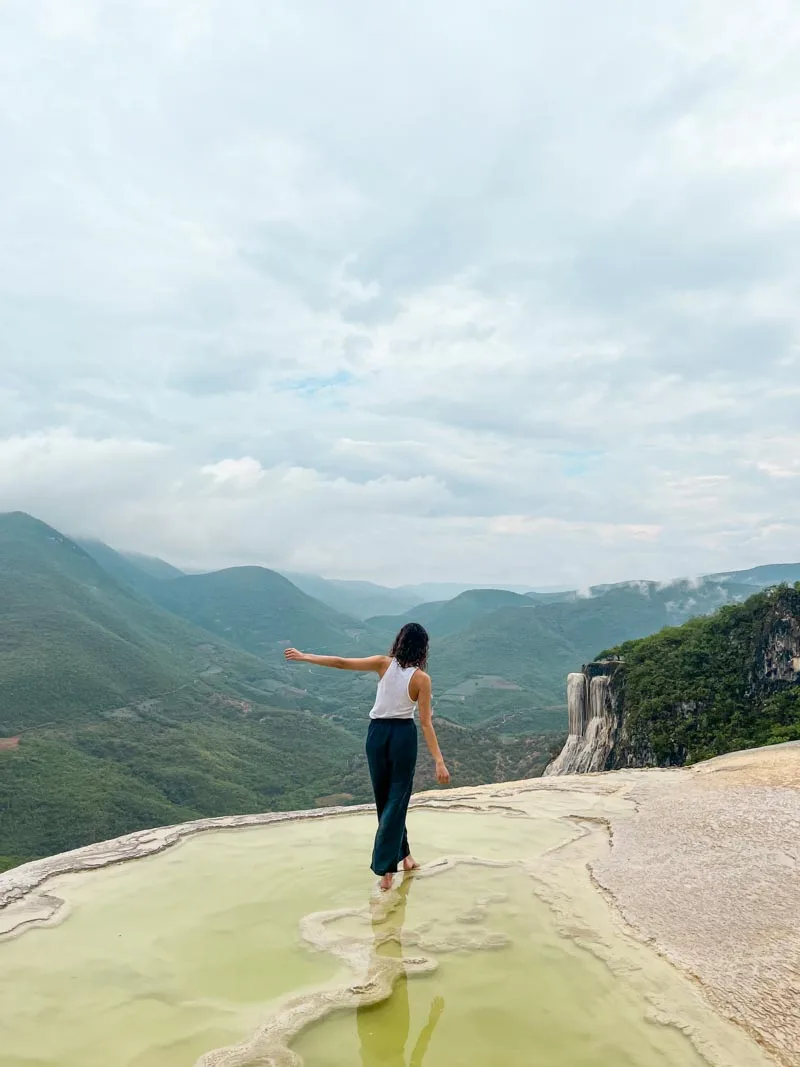 woman walking through the shallow part of hotsprings at hierve el agua in oaxaca