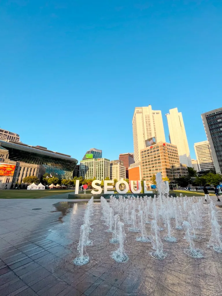standing sign in white letters spelling "I seoul you", seouls tourism slogan in front of the city's hall