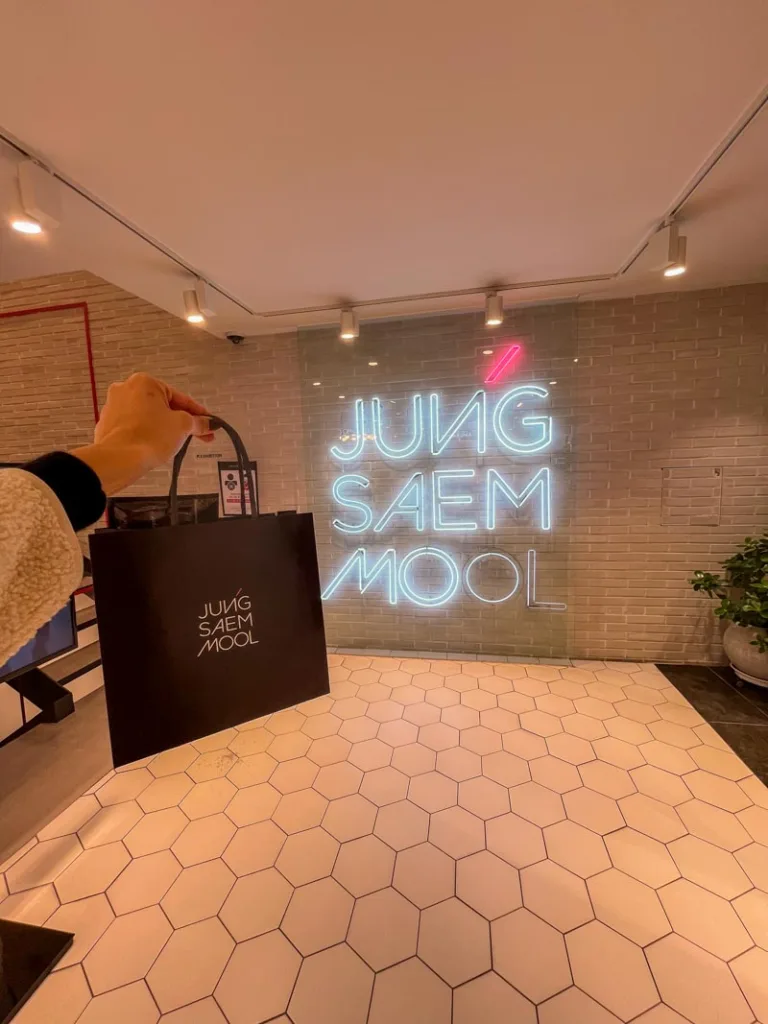 hand holding a shopping bag at Jung Saem Mool Flagship shop in Seoul