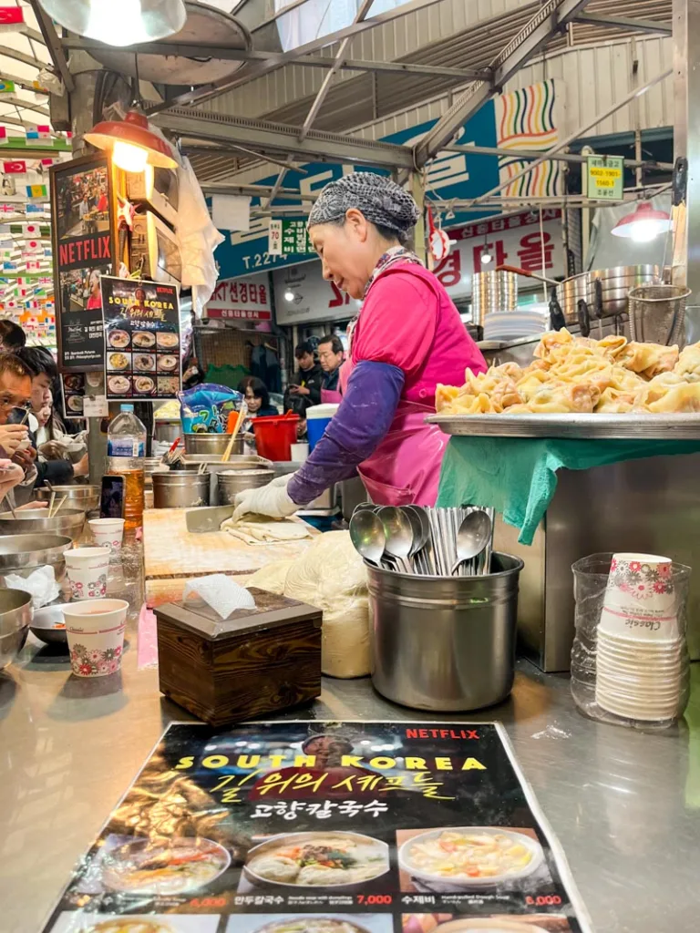 the famous woman from the knife cut noodle food stand inside gwangjang market in seoul