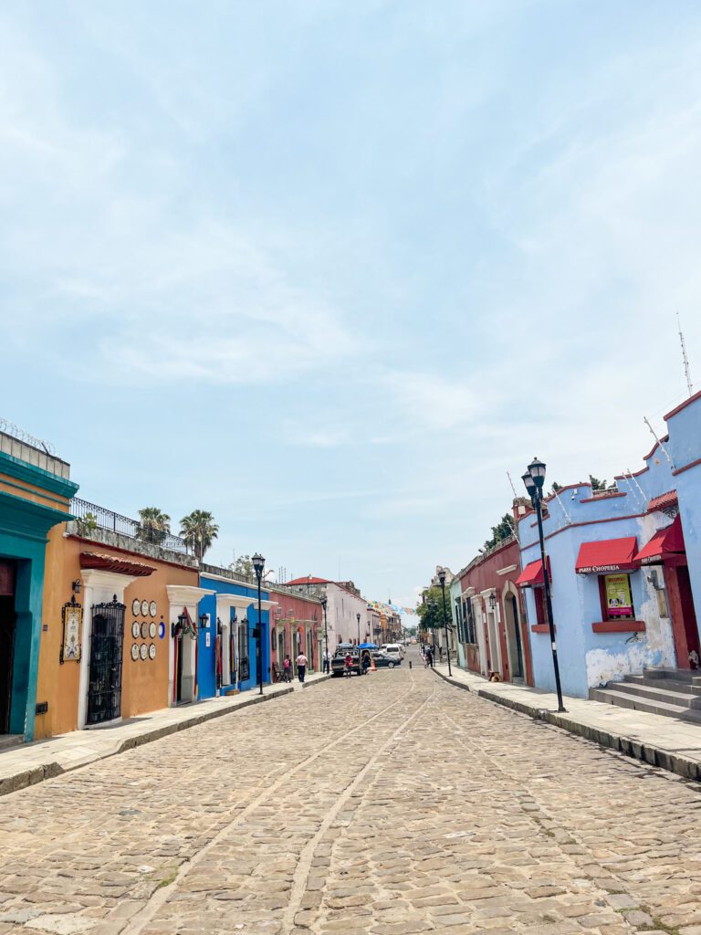 Cobblestone street lined with colorful colonial houses in in Oaxaca City