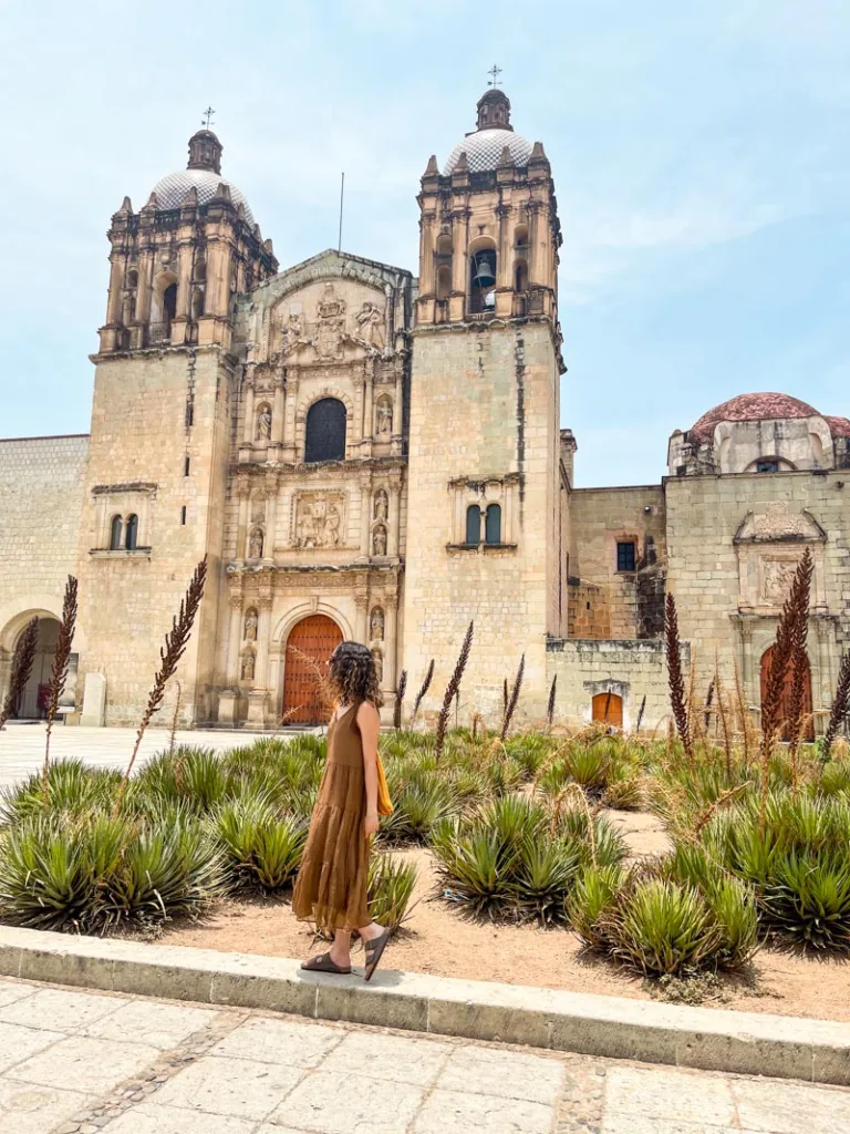 woman standing in front of the santo domingo church in oaxaca city