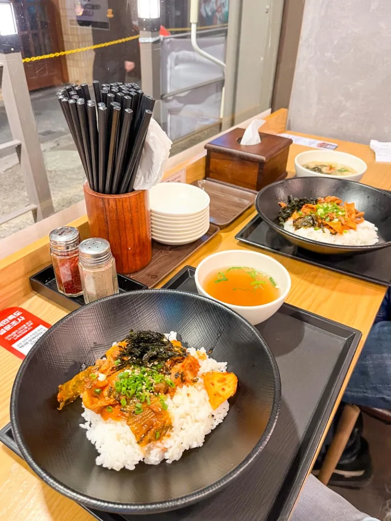 two rice bowls topped with beef, and a small soup at an interaction-free restaurant in seoul