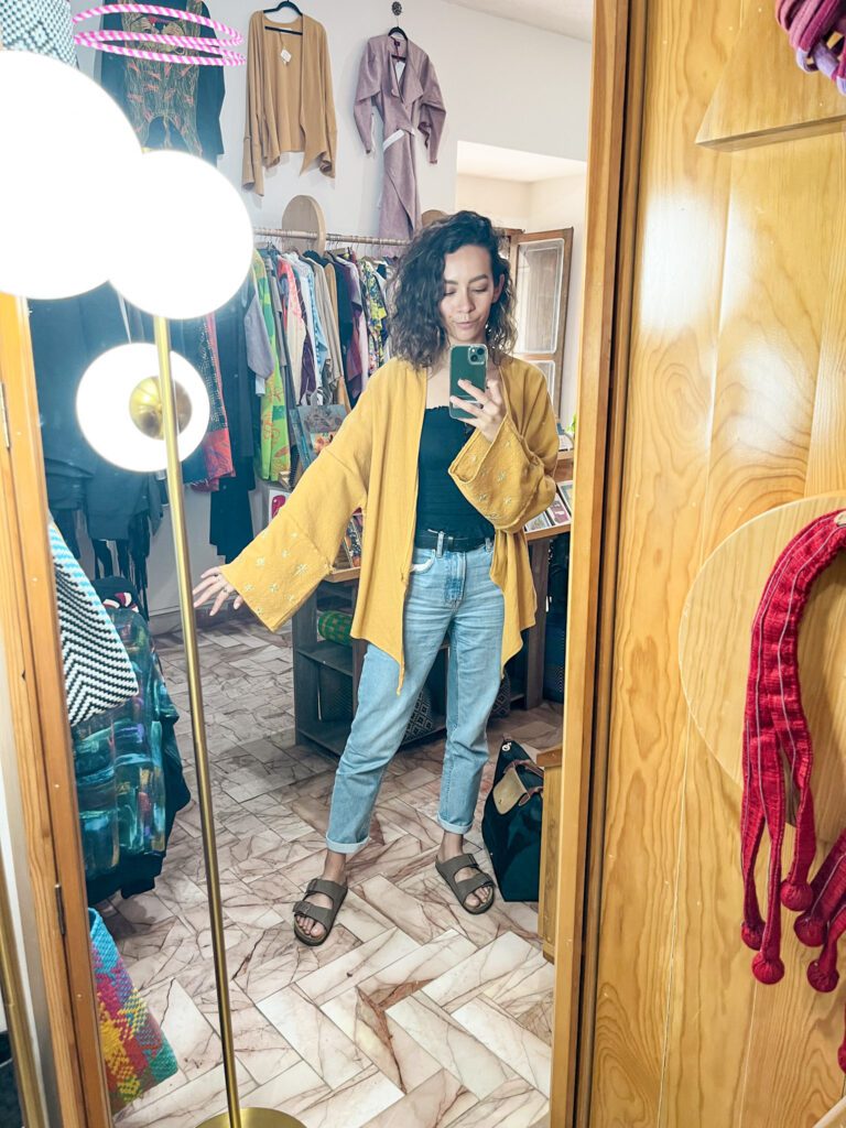 Woman trying on a yellow cover up at a boutique shop in Oaxaca City