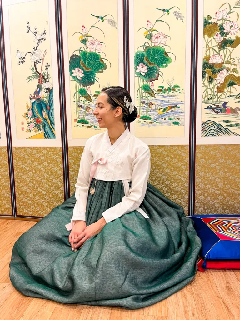 woman sitting down on the wooden floor dressed in full hanbok attire in seoul