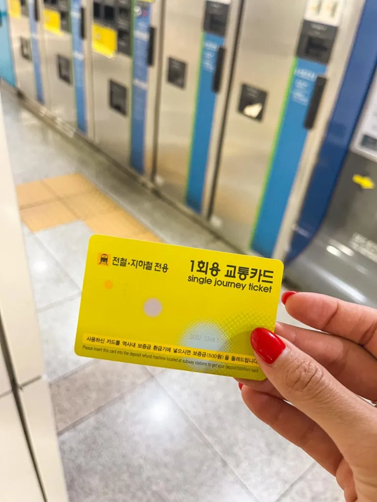 Hand holding a single journey ticket for the Seoul metro