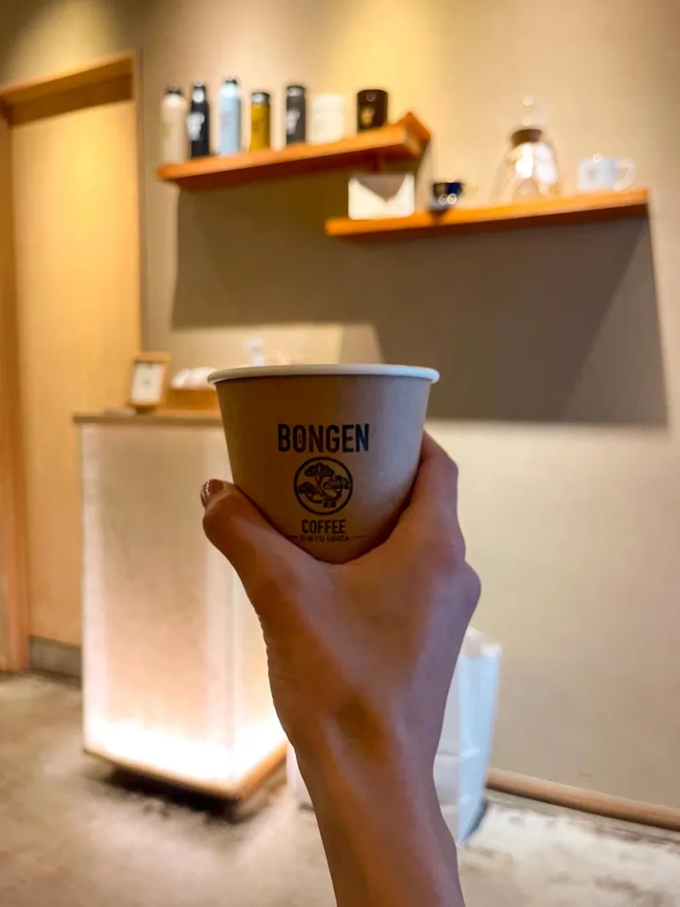 hand holding a to-go coffee cup at bongen coffee shop in tokyo