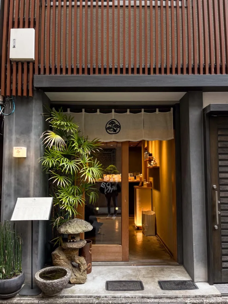 black facade of bongen coffee shop in tokyo with a bonsai tree by the door