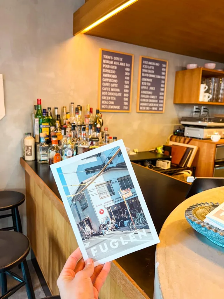 hand holding coffee shop post card at fuglen coffee shop in tokyo