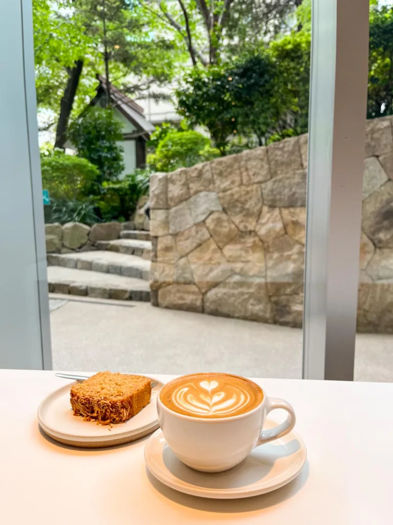 a latte and a banana bread on a plate at blue bottle, one of the best coffee shops in tokyo