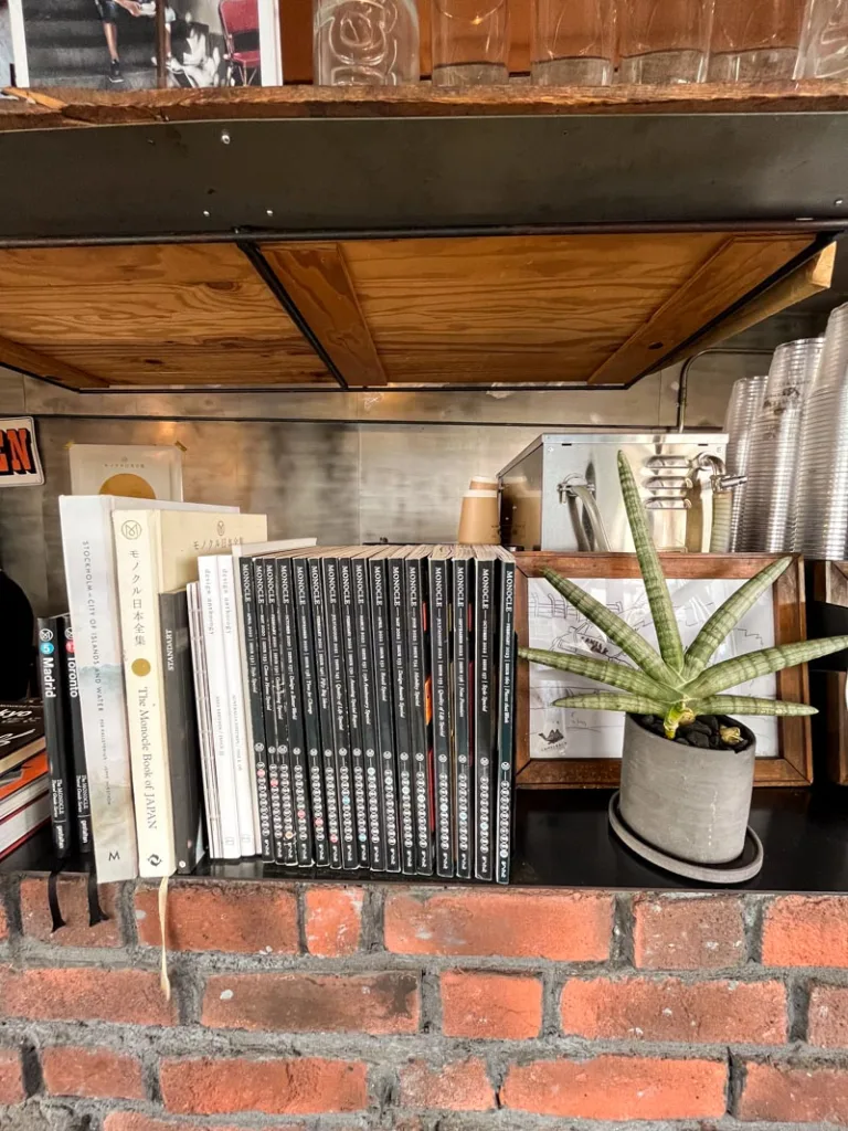 stack of books on a red brick bookshelve at camelback coffee shop in tokyo