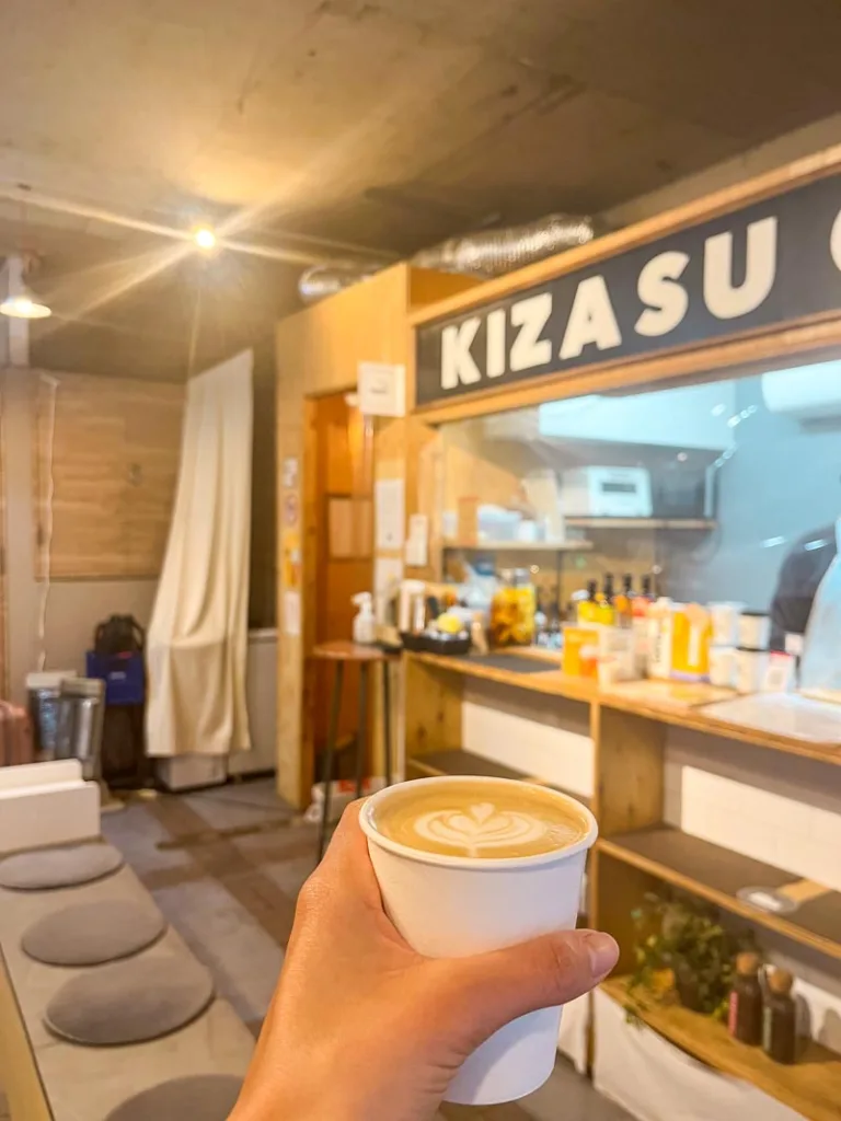 hand holding a to-go coffee cup at kizasu coffee shop in tokyo