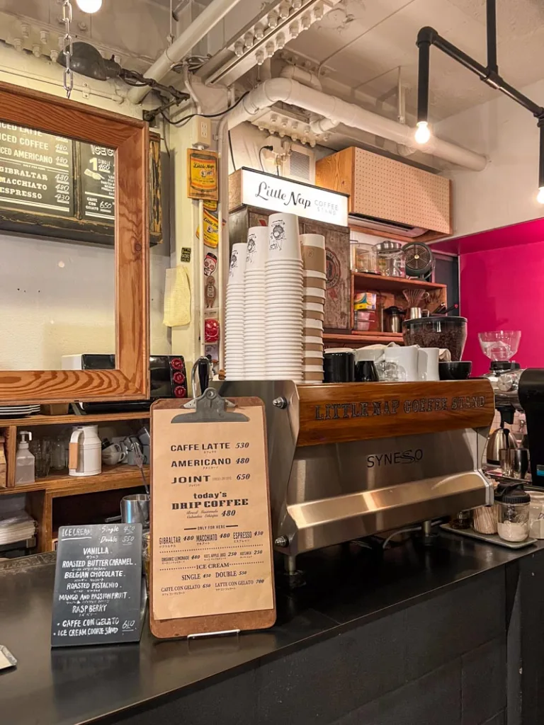 menu and espresso machine on a black coffee bar at little nap coffee shop in tokyo