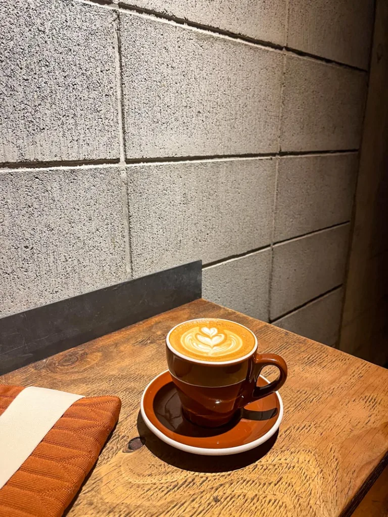 rust-colored ceramic coffee cup on a wooden bar at roastery by nozy coffee shop in tokyo
