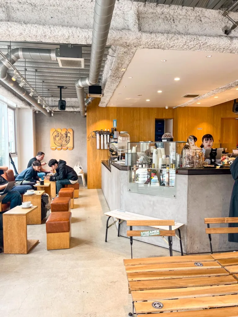 wooden small tables, stools, and the coffee bar at tokyo streamer coffee shop