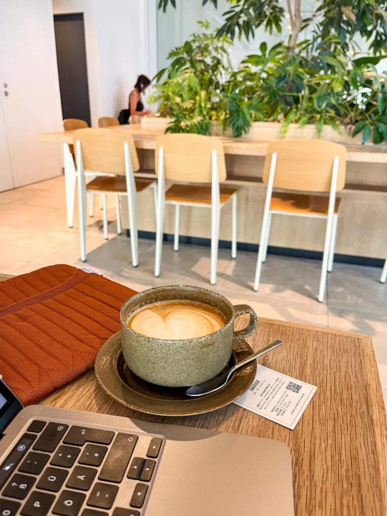 laptop and a lattee on a wooden table at verve coffee roasters in tokyo