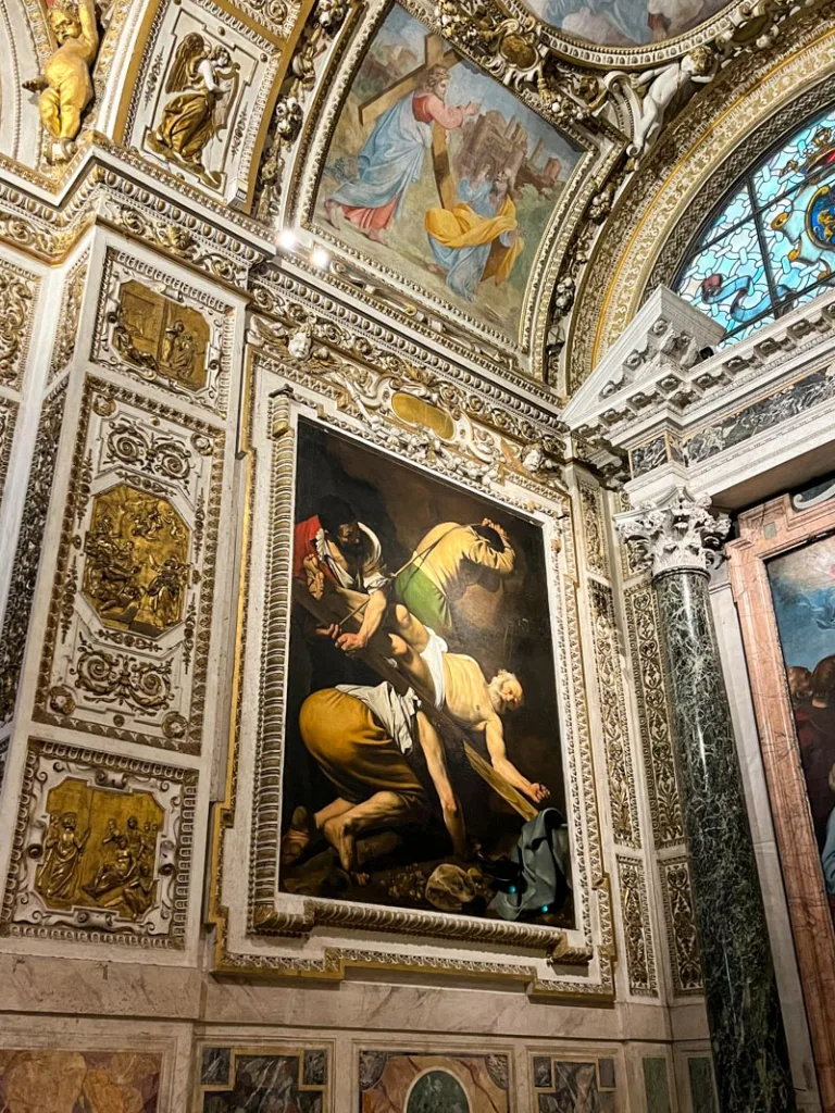 ornamented walls and a caravaggio painting on display at Basilica Parrocchiale di Santa Maria del Popolo in rome