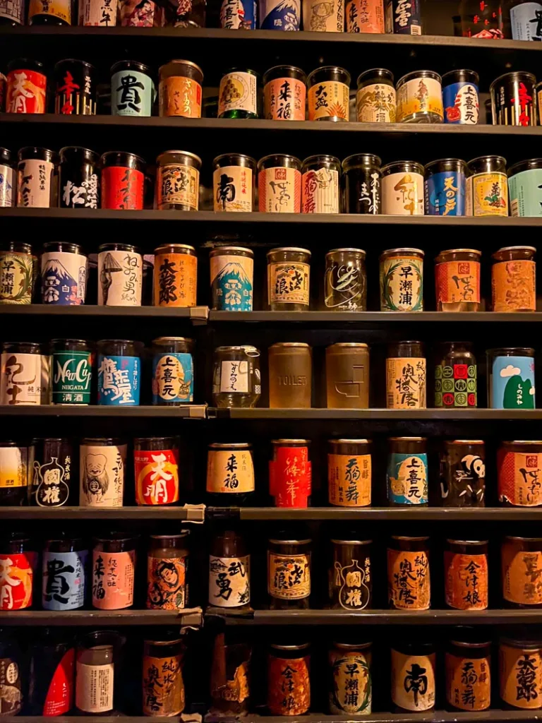 shelves filled with individual sake cups at buri sake bar in ebisu, tokyo