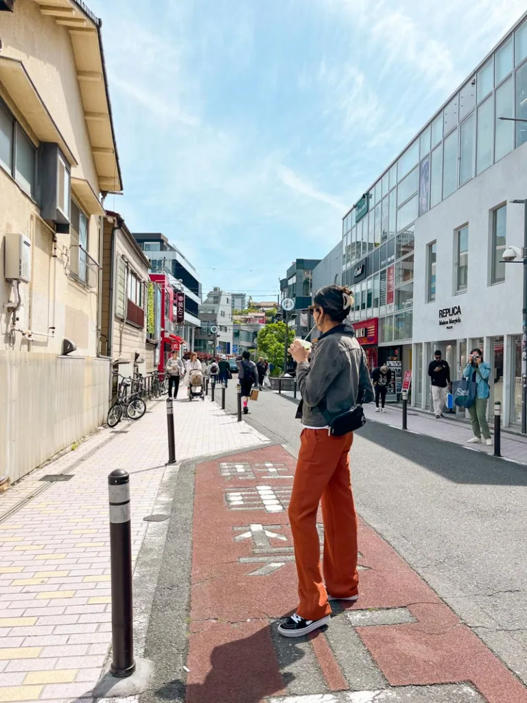woman standing with her back to the camera holding a matcha in cat street tokyo