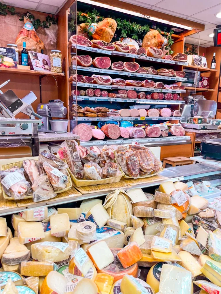 all types of cold cults and cheeses on display at a local grocery store in rome