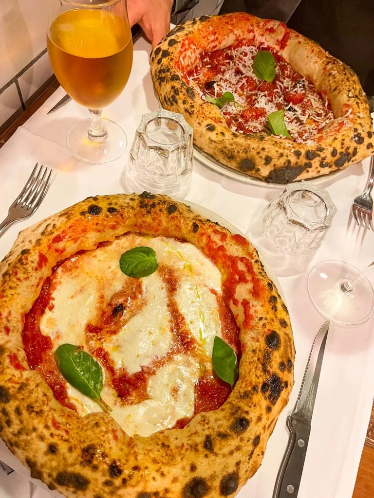 one margherita pizza and a diavola with fluffy crust on a table at piccolo buco in rome