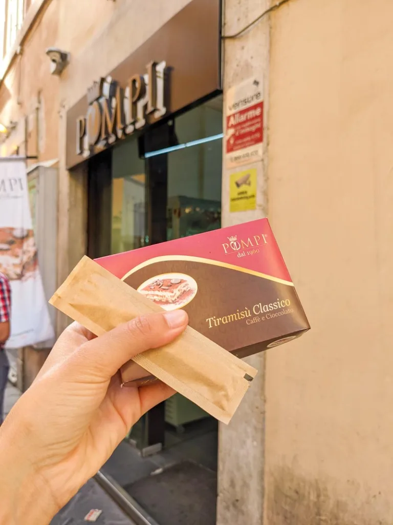 hand holding an individual sized box of pompi tiramisu in rome