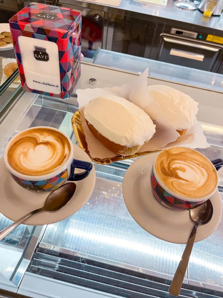 two maritozzo, and two cappuccinos on the bar a regoli pasticceria in rome