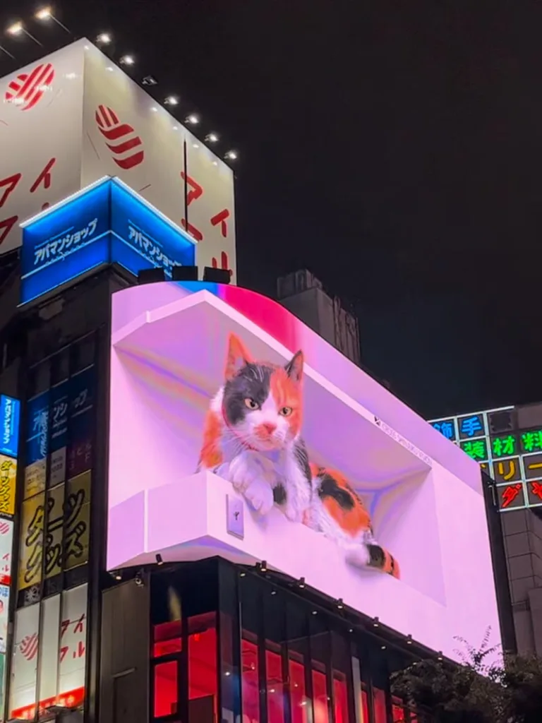 massive screen showing the famous 3-d cat in shinjuku, tokyo