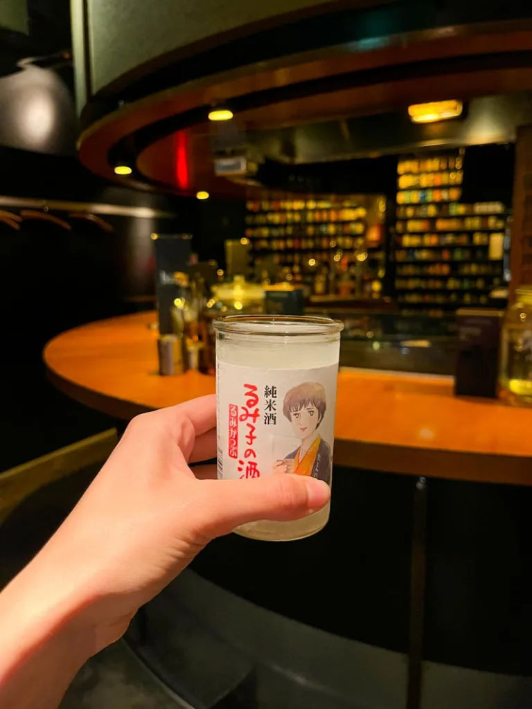 hand holding a sake cup at buri bar, one of the most unique experiences in tokyo