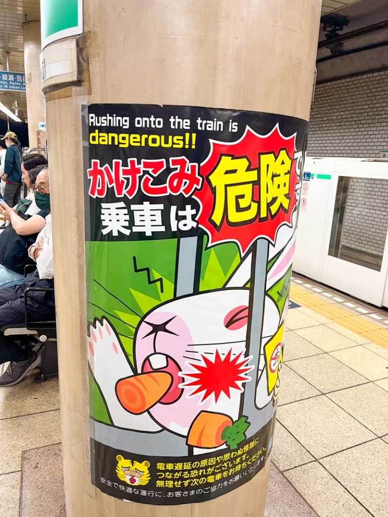 cute metro sign in tokyo showing a bunny chewing a carrot getting trapped in a metro door