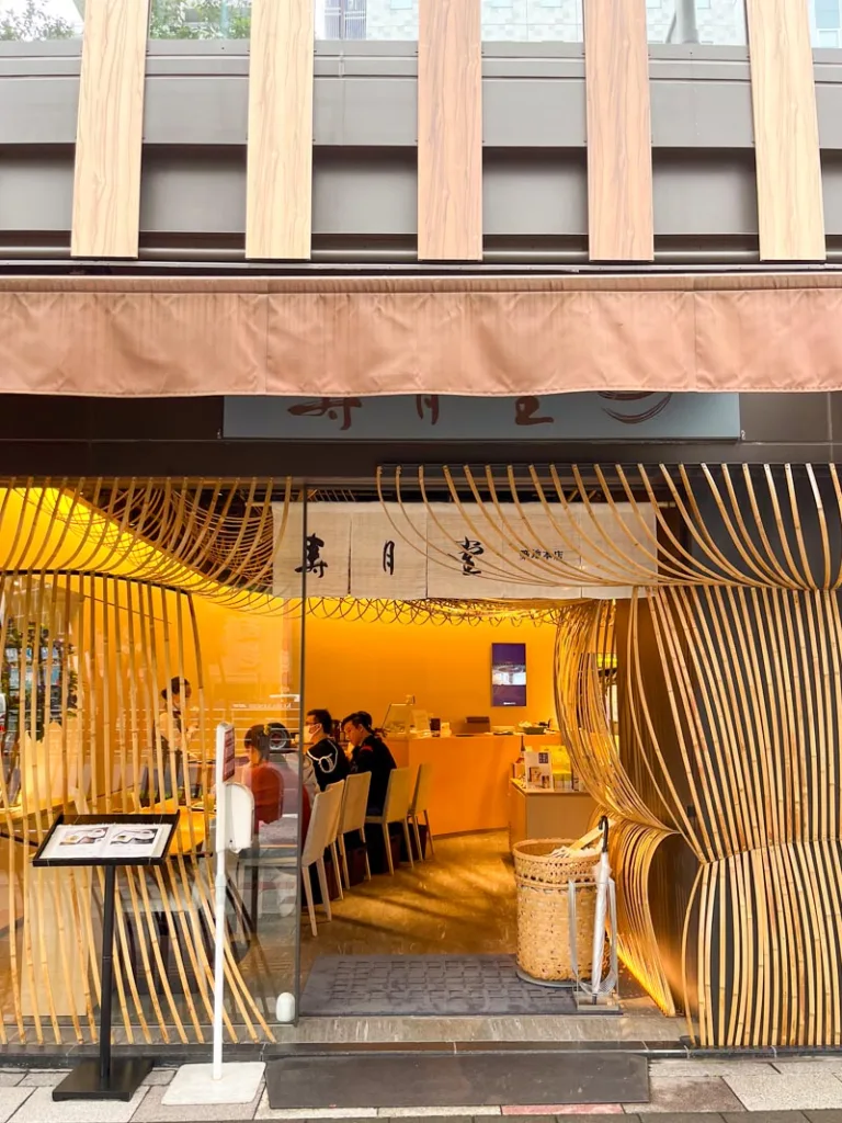 a tea shop with wooden decoration on the outside that looks like a matcha whisk in tokyo