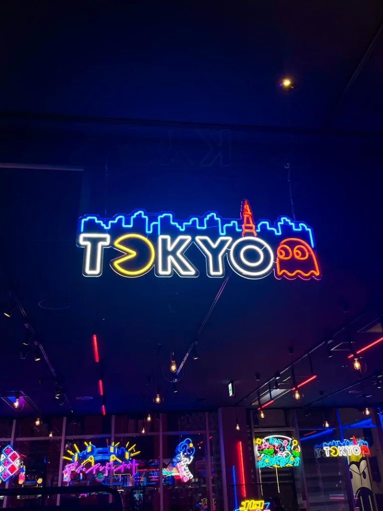 a tokyo neon sign with a pacman ghost next to it at kabukicho tower in tokyo