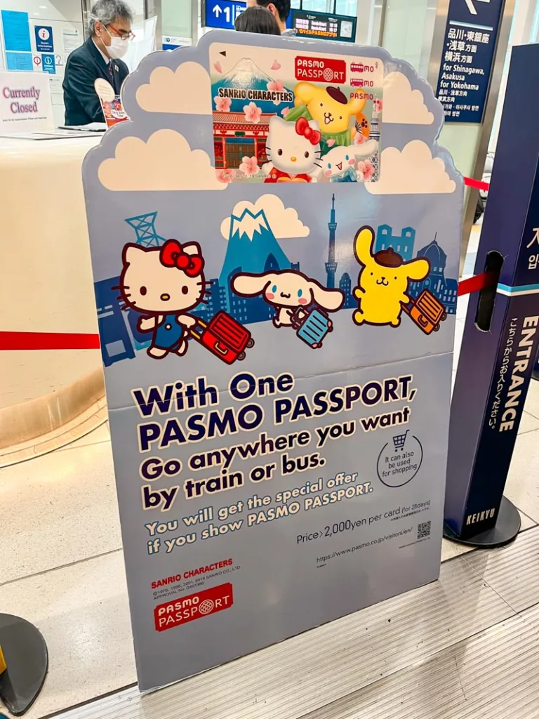 cardboard advertisement for the sanrio pasmo card at the tokyo airport with cute images of hello kitty and pikachu