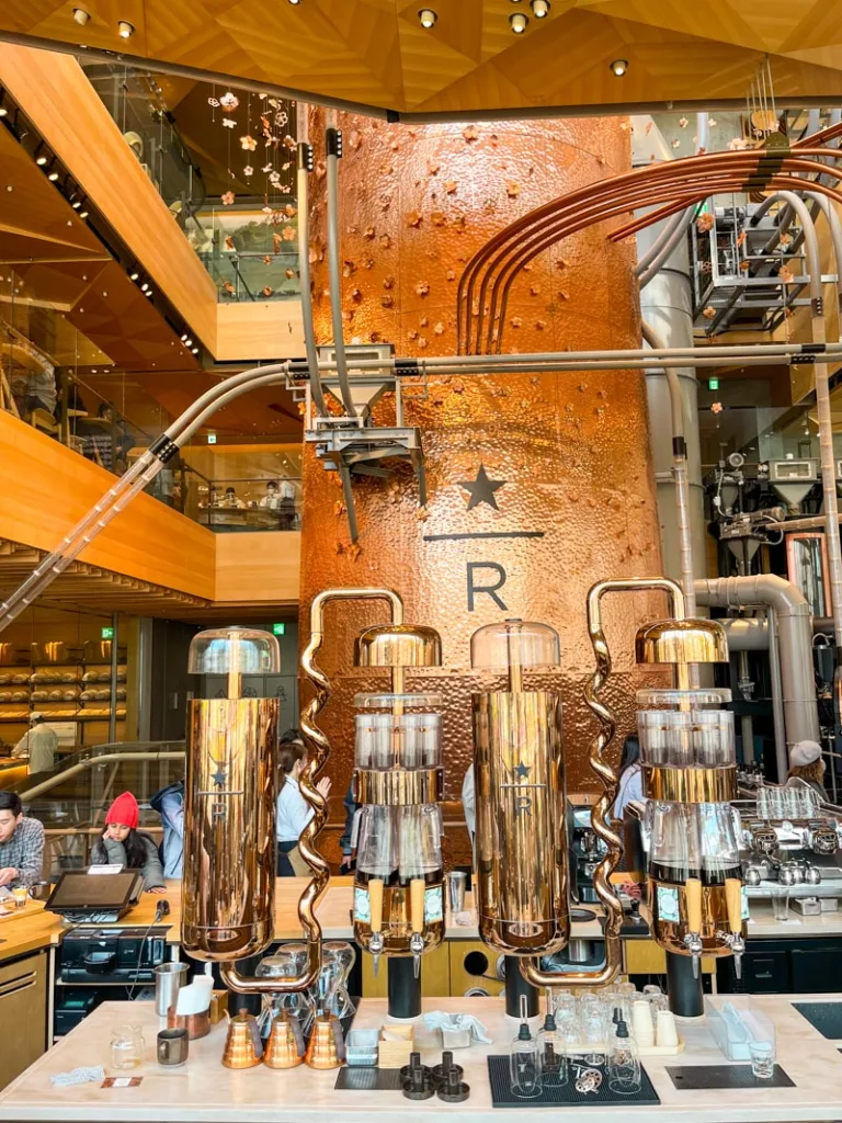 copper colored walls and complicated coffee machinery at starbucks roastery in tokyo