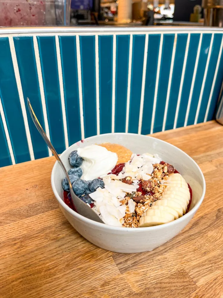 bowl of porridge topped with banana, blue berries, coconut flakes and peanut butter at grod in copenhagen