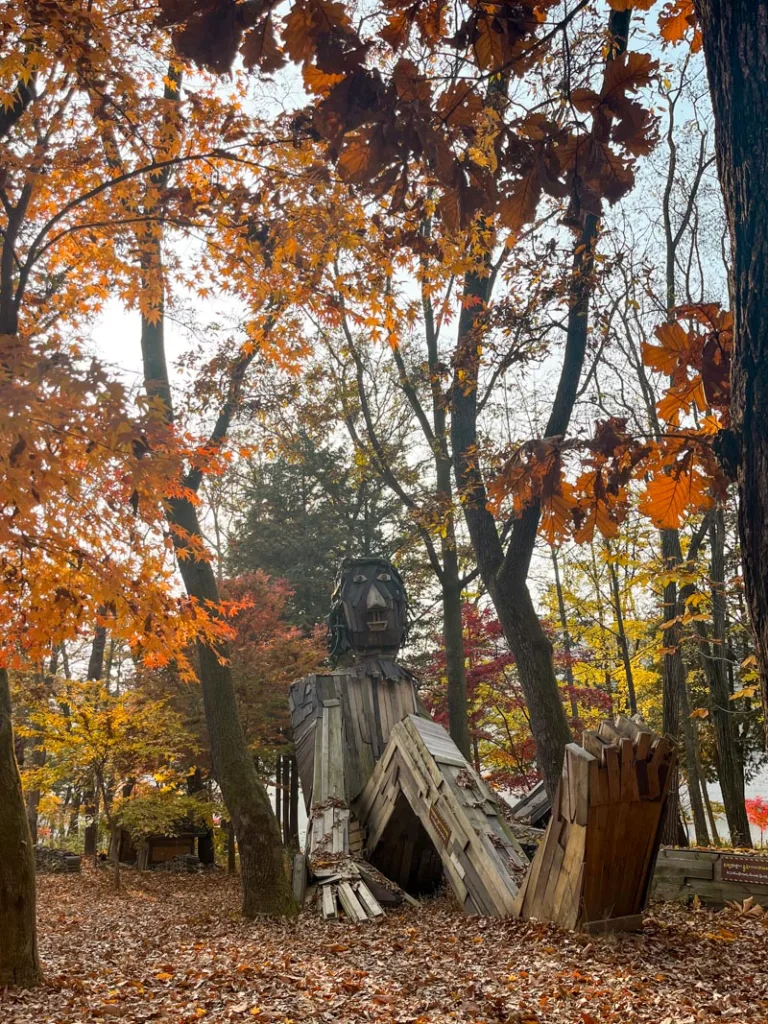 massive wooden structure that looks like a sitting giant in the woods of nami island, south korea