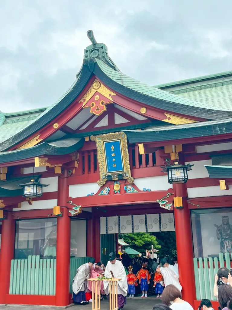a ceremony taking place in front of the colorful hie shrine in tokyo