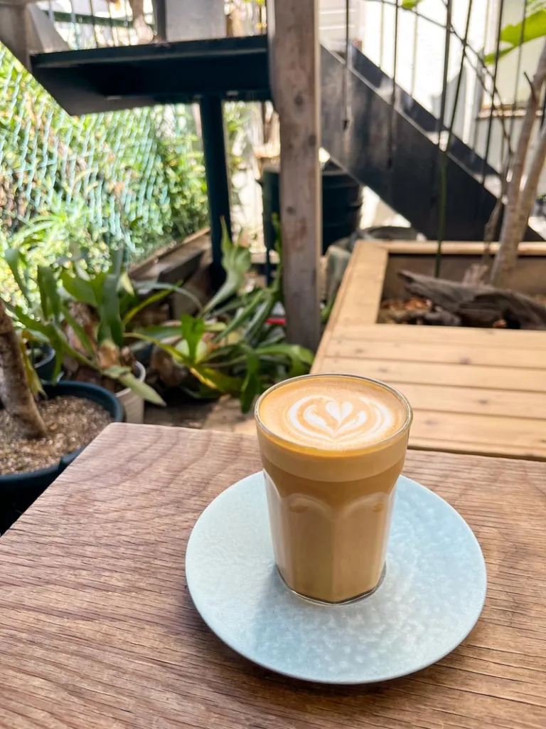 latte on a small white plate on a wooden bar at onibus coffee shop in nakameguro, tokyo