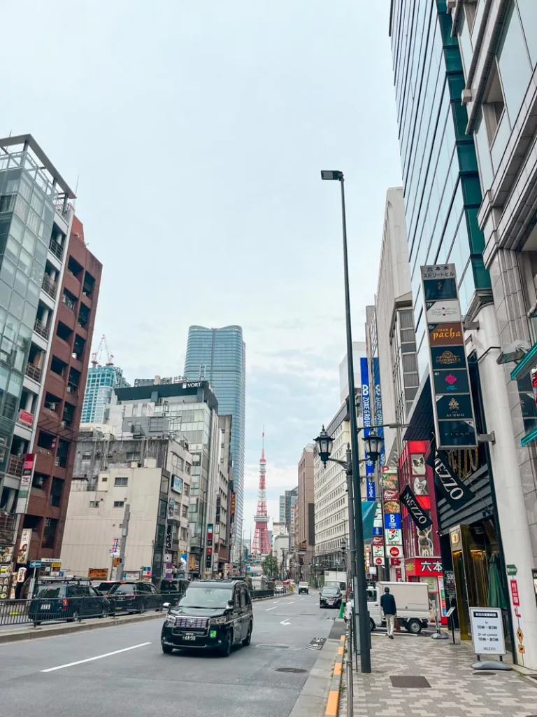 buildings lining the street and a view of the tokyo tower at the end of the road in roppongi, tokyo