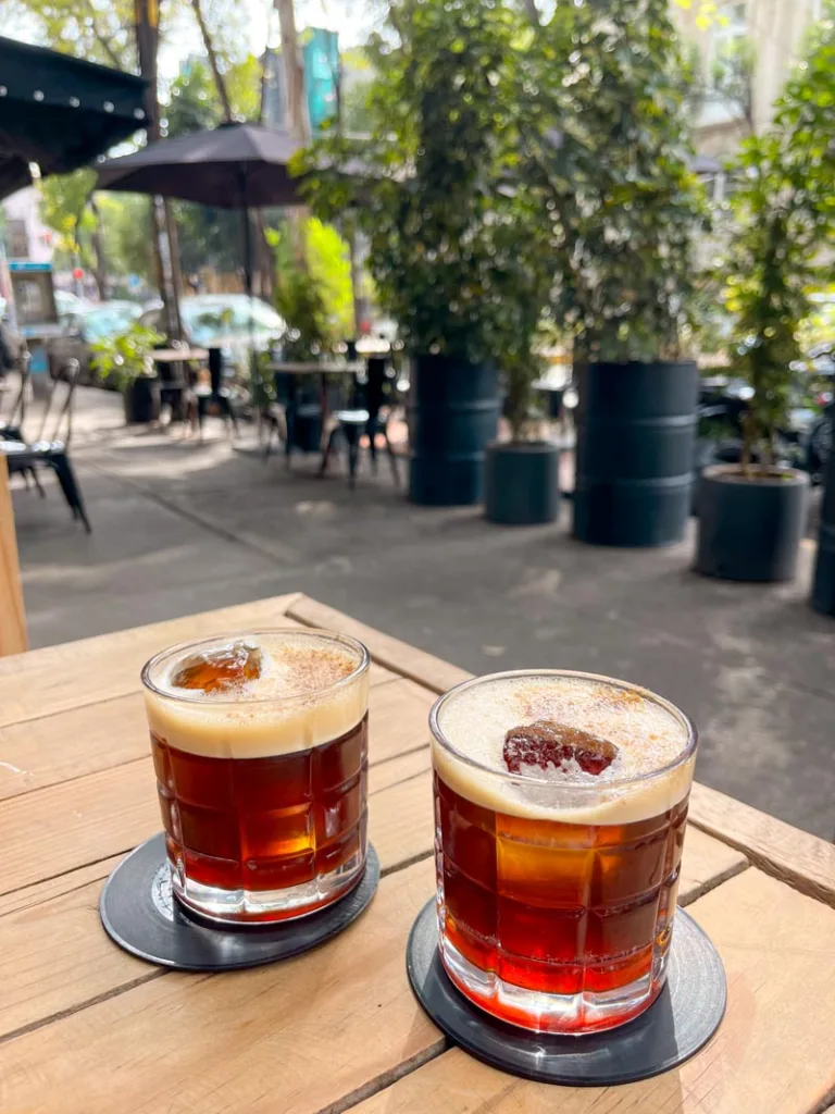 two carajillos on an outdoor wooden table at brew brew bar in mexico city