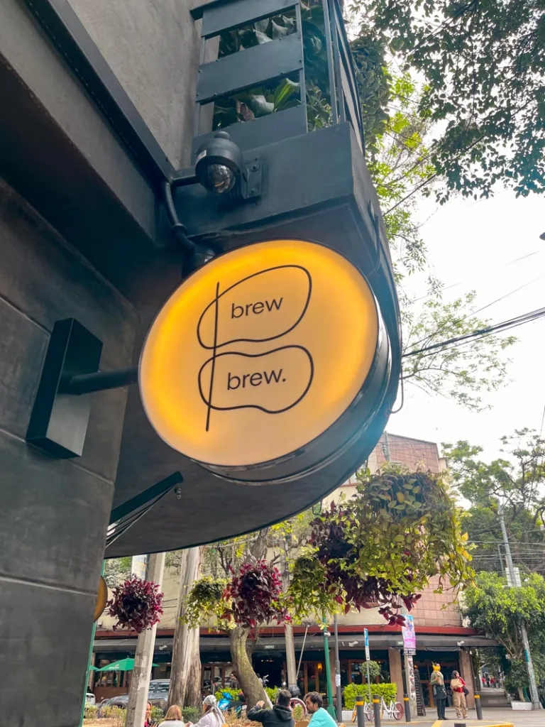 a round business sign with the logo of brew brew bar in mexico city