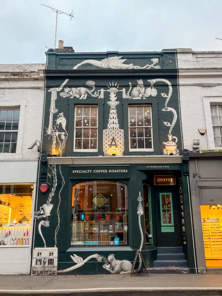 black facade with white painted art on it at amoret coffee shop in london